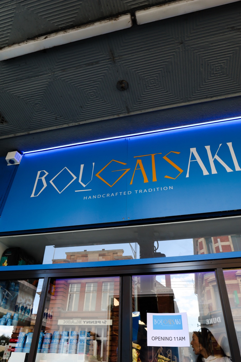 The Bougatsaki shopfront on Sydney Road, Brunswick, with its blue illuminated sign