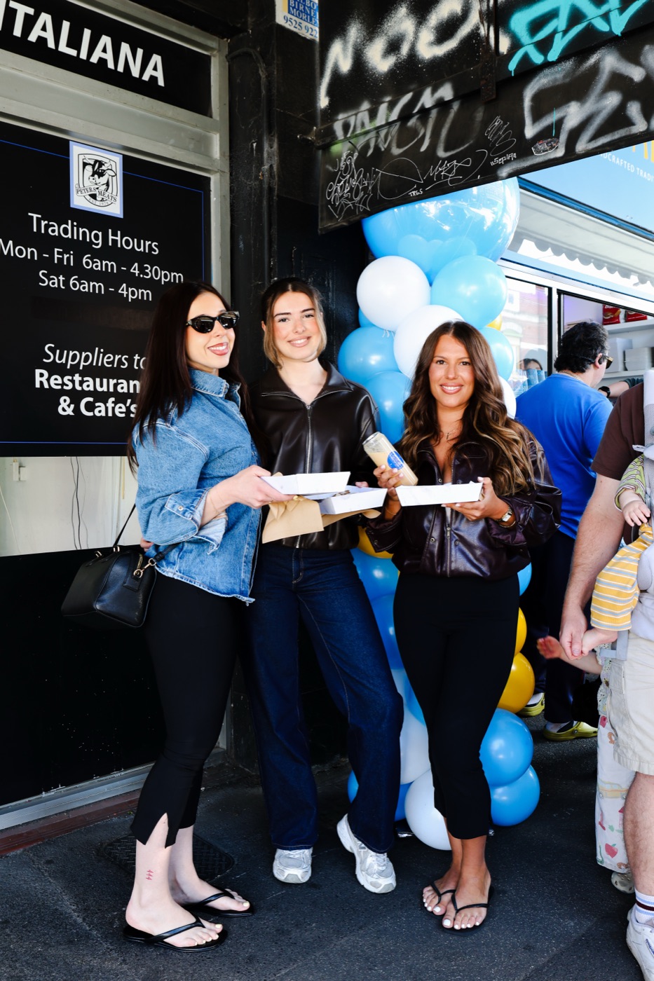 Friends holding trays of bougatsa outside the Bougatsaki store